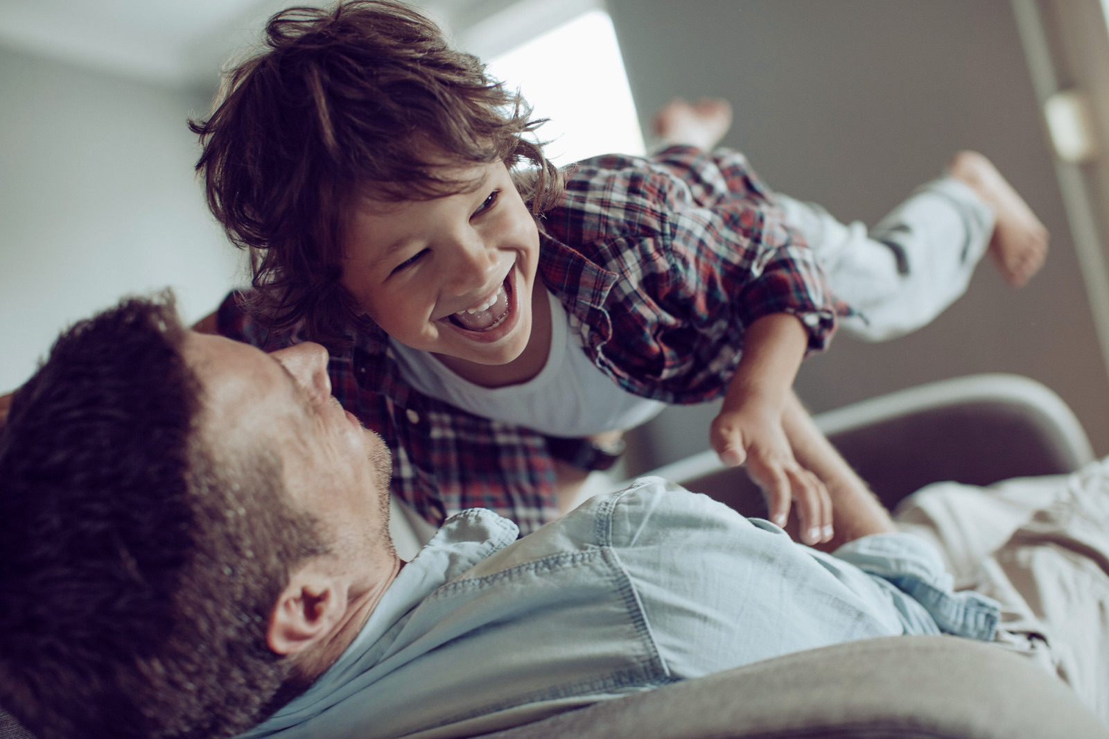 Father playing with his young son at home
